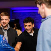 A grad shakes President Mantella's hand surrounded by grads
